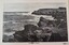 Black and white photograph of waves crashing against rocky cliffs on the shoreline