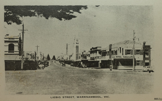 Looking down a street at a T intersection. Buildings line both sides, including two storey buildings 