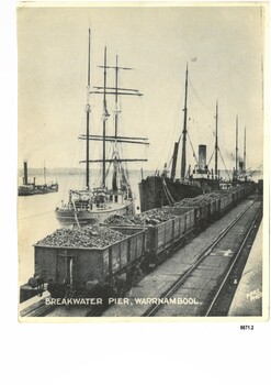Black and white photograph of Breakwater Pier in Warrnambool, with coal trucks and ships.