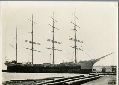 Black and white photograph of a four masted barque moored at a dock.