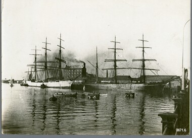 Black and white photograph showing two sailing ships moored at a dock