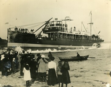 Black and white photograph of a crowd watching a steamer being launched 
