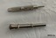 Two cigar piercers used to pierce the mouth end of a cigar so it can be smoked.