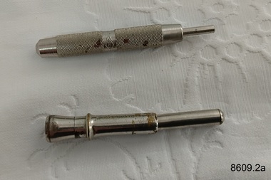 Two cigar piercers used to pierce the mouth end of a cigar so it can be smoked.