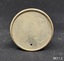 A two-piece round metal cigar piercer with a hollow spike in the middle of the base and a metal protective top.