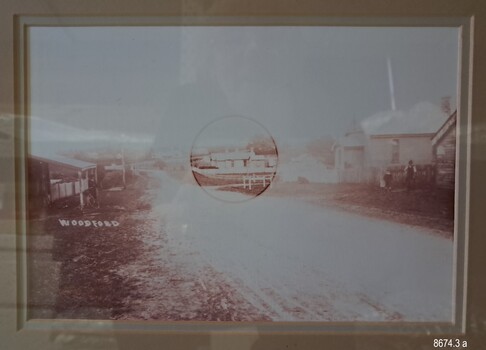 Image of an unmade road with old buildings each side, one is encircled