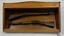 Glass fronted wooden case containing two mounted rifles