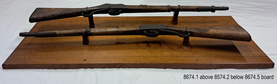 The rifles are each mounted on two pedestals. View is from the bottom towards the top