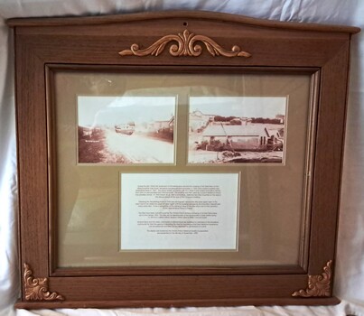 Wooden frame with glass front, containing two photographs and a document