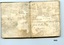 Two white pages in pocketbook showing navigational calculations and owner's name written in black ink 