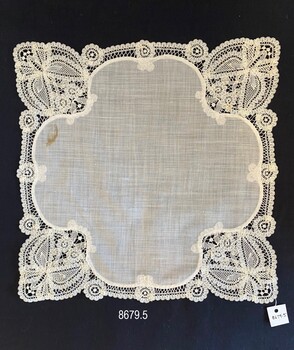 Fine hanky with intricate lace pattern in each corner.