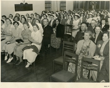 Sepia photograph of nurses and guest seated in rows at an official function
