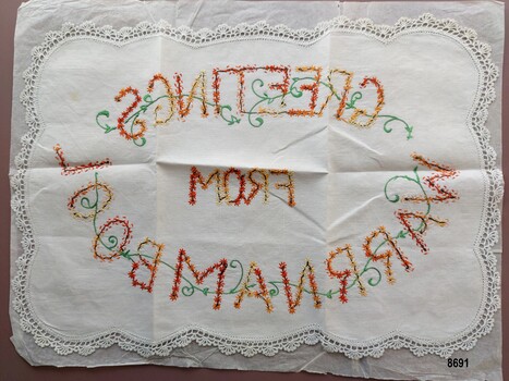 Rectangular tray cloth with crocheted edging and embroidered message.