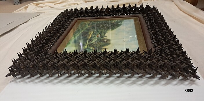 Oil painting with frame made from hundreds of small wooden pegs