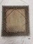 Wooden back of oil painting and back of frame showing diagonal wooden struts and length of wire