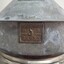 Close-up of the centre, square brass plaque with maker and logo