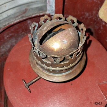 Brass oil burner mounted on its red tank