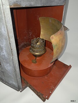 Oil burner and reflector on tray, which is half removed from lamp