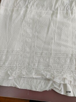 Hem detail on petticoat showing eyelet design and pinspot fabric.