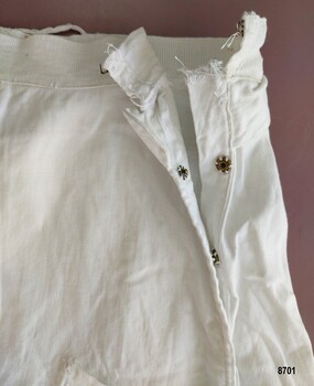 Opening of overskirt with hook and eye and snap fasteners.