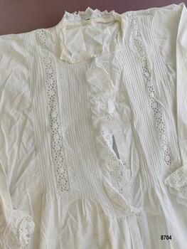 Bodice featuring front opening placket and decorative pintucking and lace