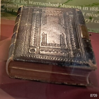 Black leather cover with red edged pages and metal clasp