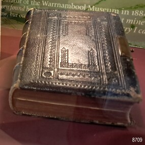 Black leather cover with red edged pages and metal clasp