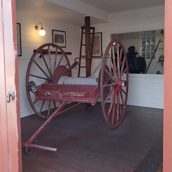 Red timber hose cart with fitting for hose nozzle and lamp