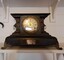 Dark wood, ornate mantle clock frame with gilt decoration.