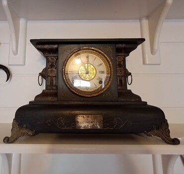 Dark wood, ornate mantle clock frame with gilt decoration.
