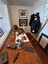 Mounted photographs on the wall, objects on the table