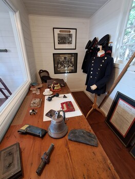 Mounted photographs on the wall, objects on the table