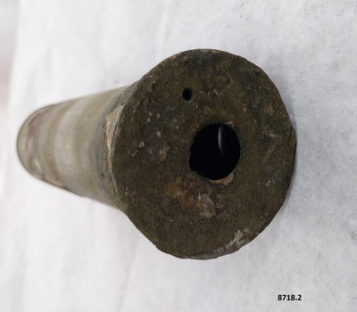Brass cylinder with a small circular hole in the end.