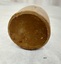 Bottom of clay inkpot showing darker surface with minor pitting of surface.
