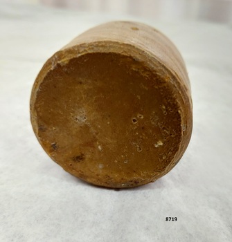 Bottom of clay inkpot showing darker surface with minor pitting of surface.
