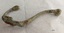 Brass coat hook with extensive verdigris patina and attachment plate (with screw holes) broken on both sides of main shaft.