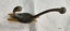 Metal, two-pronged coat hook attached to fragment of wood. Some brown and green oxidation.