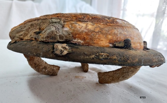 Circular iron frame with domed glass projecting above and three curved lugs projecting below.