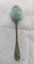 Back of silver tablespoon with green patina on base of "bowl" and neck of spoon
