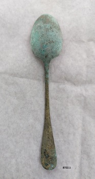 Back of silver tablespoon with green patina on base of "bowl" and neck of spoon