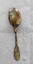 Back of dessert spoon, with fiddle back handle with inscription. Has green and black tarnish and the bowl is heavily encrusted.