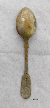 Spoon with fiddle back design on both ends of handle. It has silver marks stamped on handle and is displaying brown oxidation.
