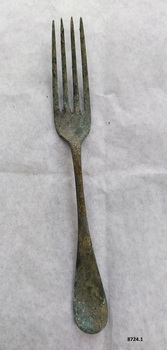 Large dinner fork with green and brown patina.