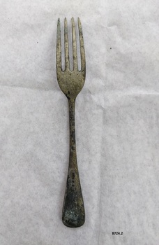 Metal dessert fork showing signs of wear on handle. Four unreadable maker's marks on handle.