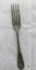 Dessert fork with rounded handle and some black and green tarnish.