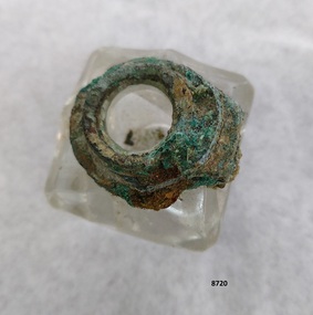Square, clear glass inkwell with verdigris oxidation on collar.