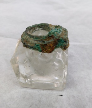 Square glass inkwell with verdigris oxidation on collar and hinge.