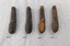 Four pocket knives, all of a similar design, showing different degrees of damage and wear.