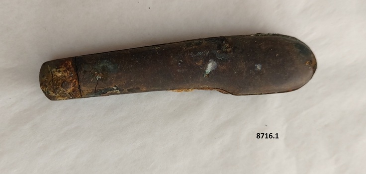 Pocket knife with metal top showing some corrosion and a brown wooden handle. 