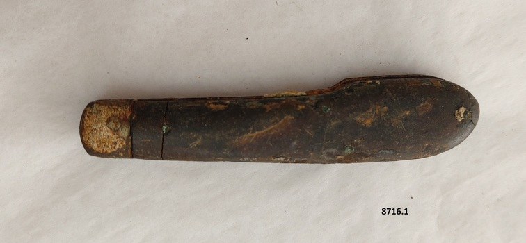 Other side of pocket knife showing a thin crack across the top of the brown handle.
